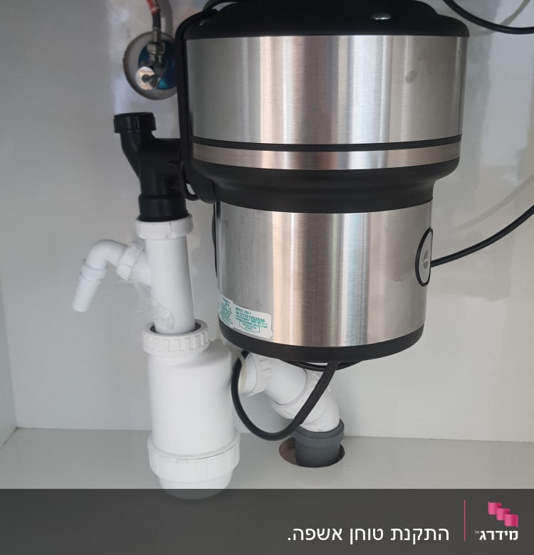 מתקן טוחן אשפה מתחת לכיור עם צינורות חיבור